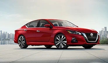 2023 Nissan Altima in red with city in background illustrating last year's 2022 model in Waxahachie Nissan in Waxahachie TX