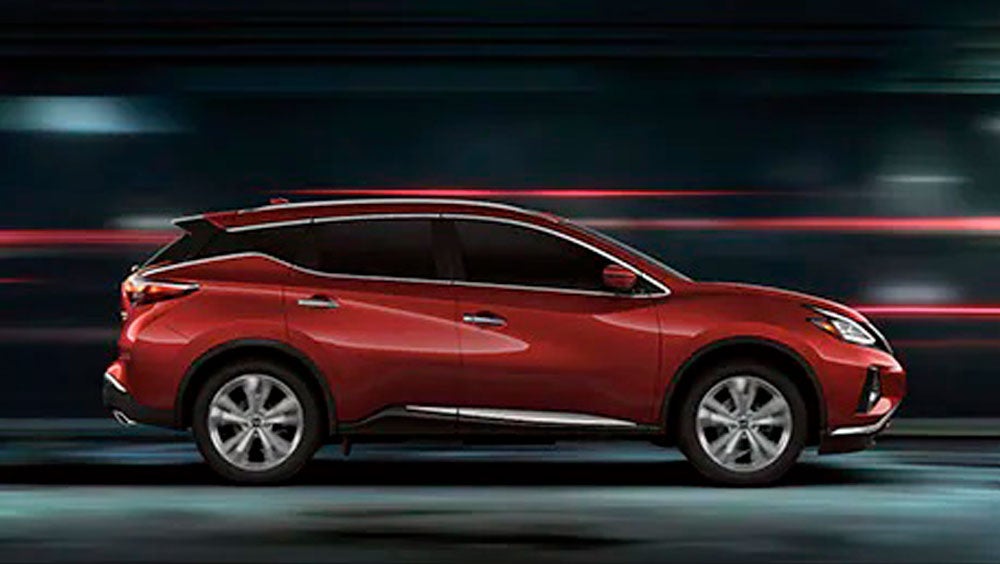 2023 Nissan Murano shown in profile driving down a street at night illustrating performance. | Waxahachie Nissan in Waxahachie TX